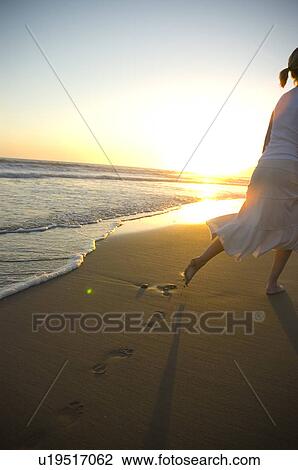 Young female on the beach at sunset View Large Photo Image Stock Image - Young female on the beach at sunset. Fotosearch