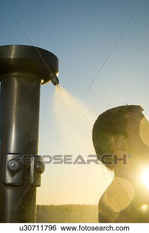 Young male surfer rinsing off in the shower View Large Photo Image Stock Photograph - Young male surfer rinsing off in the shower. Fotosearch
