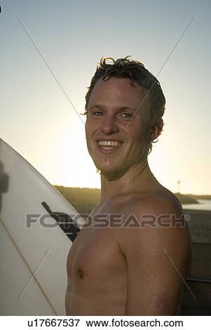Stock Photo - Young male surfer smiling. Fotosearch