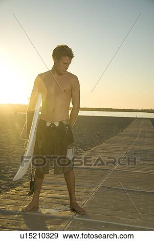 Stock Photo - Young male surfer. Fotosearch