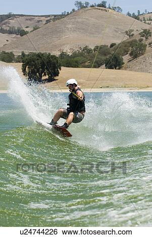 Stock Photograph - Young male wake boarding. Fotosearch