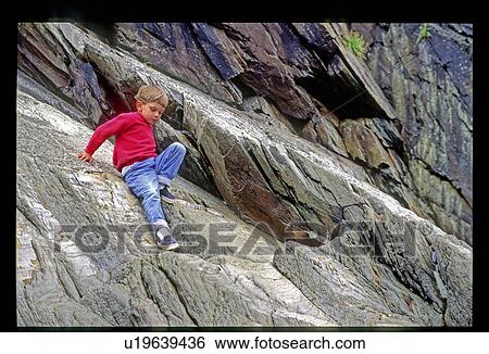 Boy climbing on rocks View Large Photo Image Stock Photograph - Boy climbing on rocks. Fotosearch