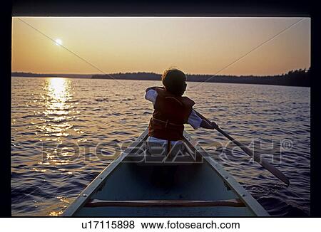 Boy paddling canoe View Large Photo Image Stock Photo - Boy paddling canoe. Fotosearch