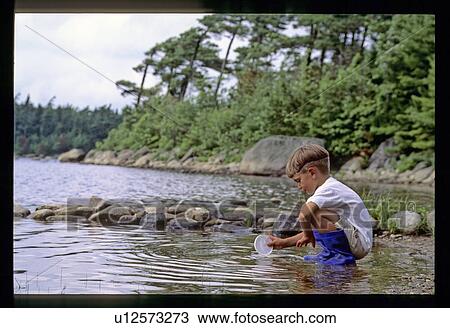 Stock Image - Boy playing in the water. Fotosearch