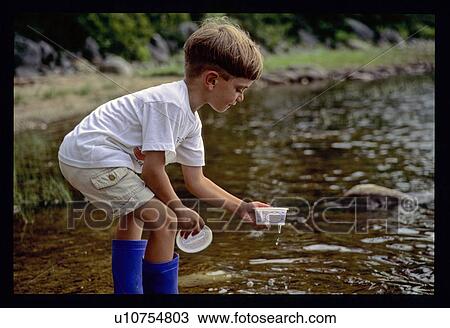 Boy playing in water View Large Photo Image Stock Image - Boy playing in water. Fotosearch