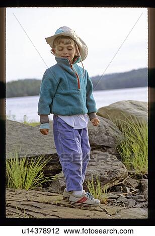 Stock Image - Boy playing on rocks. Fotosearch