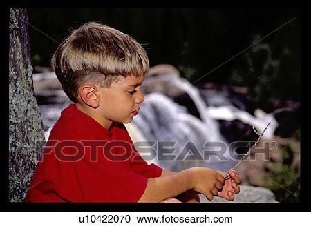 Stock Image - Boy playing with a stick. Fotosearch