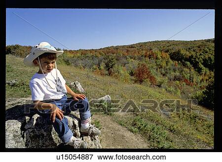 Boy sitting on a rock View Large Photo Image Stock Photo - Boy sitting on a rock. Fotosearch