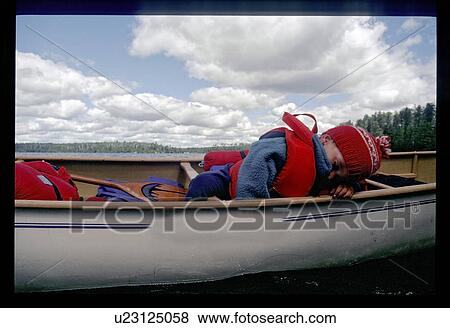 Boy sleeping in a canoe View Large Photo Image Stock Photo - Boy sleeping in a canoe. Fotosearch