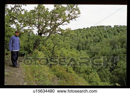Boy standing on cliffside path View Large Photo Image Stock Image - Boy standing on cliffside path. Fotosearch