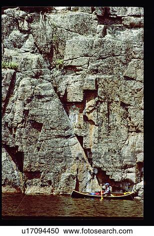 Canoeing by a rock wall View Large Photo Image Stock Image - Canoeing by a rock wall. Fotosearch