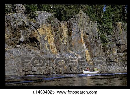 Canoeing by a rock wall View Large Photo Image Stock Photography - Canoeing by a rock wall. Fotosearch