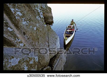 Canoeing by a rock wall View Large Photo Image Stock Photography - Canoeing by a rock wall. Fotosearch
