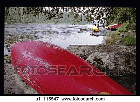 Canoes on the shoreline View Large Photo Image Stock Photo - Canoes on the shoreline. Fotosearch
