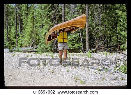Stock Image - Carrying a canoe. Fotosearch