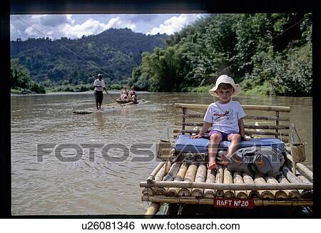 Stock Photograph - Child on bamboo raft. Fotosearch