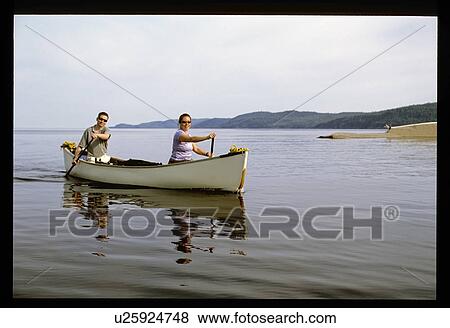 Couple paddling canoe View Large Photo Image Stock Photo - Couple paddling canoe. Fotosearch