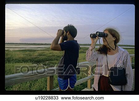 Stock Image - Couple using binoculars. Fotosearch