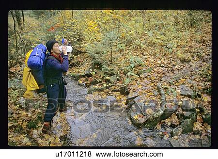 Stock Photo - Drinking during a hike. Fotosearch
