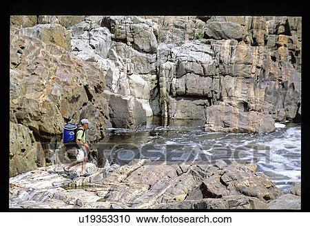 Stock Image - Hiker on rocks. Fotosearch