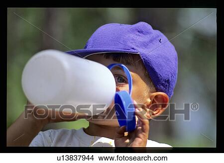 Picture - Little boy drinking from water bottle. Fotosearch