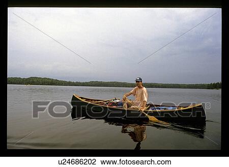 Stock Image - Man in a canoe. Fotosearch