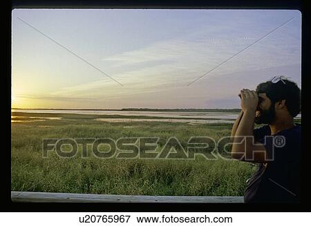 Man looking through binoculars View Large Photo Image Stock Photo - Man looking through binoculars . Fotosearch