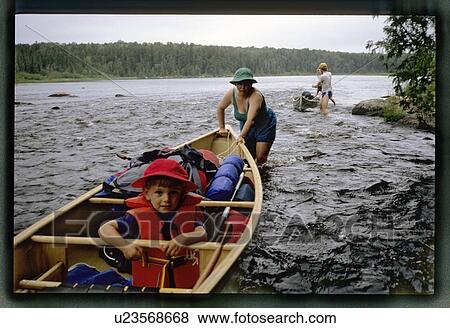 Mom pushing a boy in a canoe View Large Photo Image Stock Photo - Mom pushing a boy in a canoe . Fotosearch