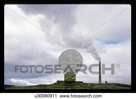 Stock Image - Monument by a smokestack . Fotosearch