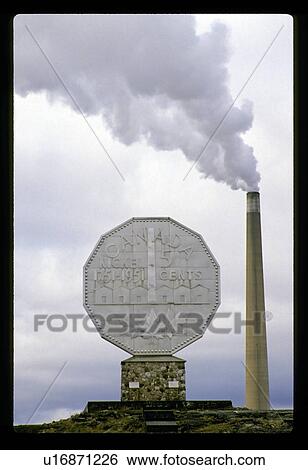 Stock Photograph - Monument by a smokestack. Fotosearch