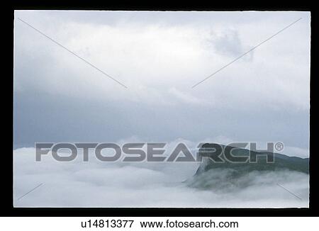 Mountaintop through the clouds View Large Photo Image Stock Photo - Mountaintop through the clouds. Fotosearch