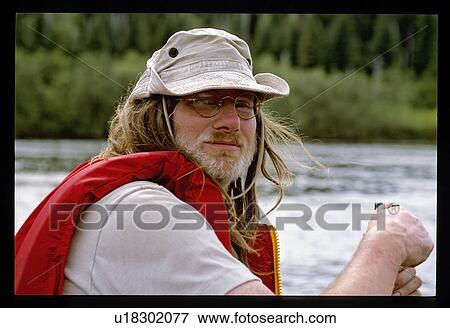 Stock Photo - Outdoors man in a canoe. Fotosearch