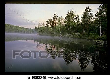 Stock Photograph - Peaceful lake shoreline. Fotosearch