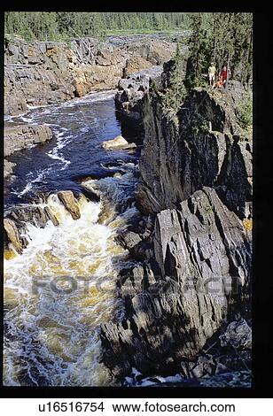 Picture - People on ledge overlooking river. Fotosearch