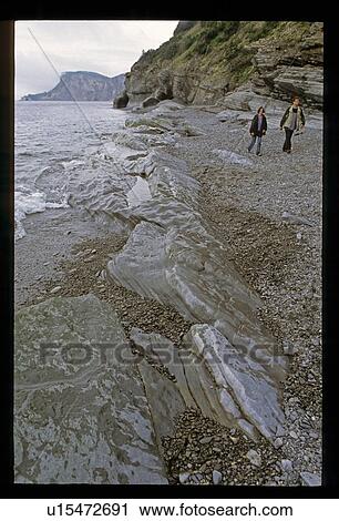 Stock Image - People walking along a coast. Fotosearch