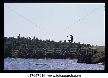 Person jumping off a cliff into a lake View Large Photo Image Stock Photograph - Person jumping off a cliff into a lake. Fotosearch