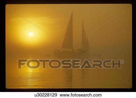 Stock Photo - Sailboats at sunset. Fotosearch