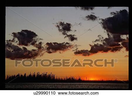 Stock Image - Sunset over a lake. Fotosearch