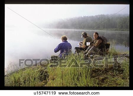 Taking a break from hiking by a pond View Large Photo Image Stock Photo - Taking a break from hiking by a pond. Fotosearch