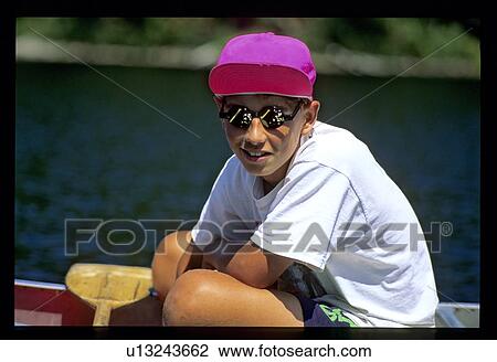 Teen boy sitting in boat View Large Photo Image Stock Image - Teen boy sitting in boat. Fotosearch