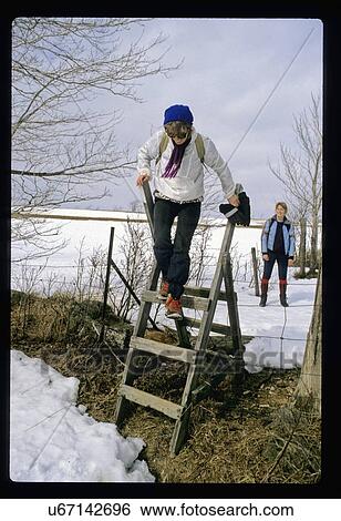 Stock Photograph - Woman jumping off a ladder. Fotosearch
