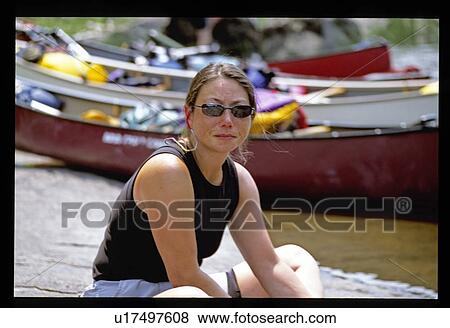 Woman with canoes in background View Large Photo Image Stock Photo - Woman with canoes in background. Fotosearch