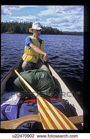 Stock Image - Young male in canoe. Fotosearch