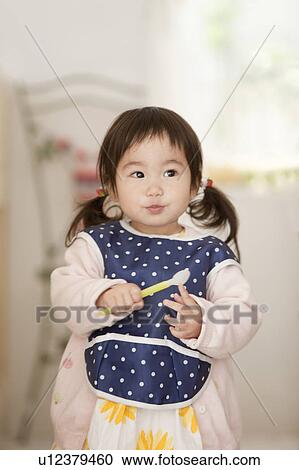 Stock Image - Baby Girl Holding Spoon. Fotosearch