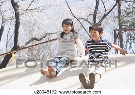 Stock Image - Boy and Girl Sliding. Fotosearch