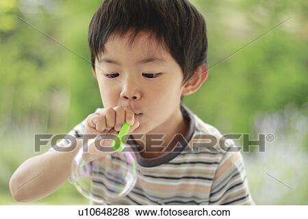 Stock Photo - Boy Blowing Bubble. Fotosearch