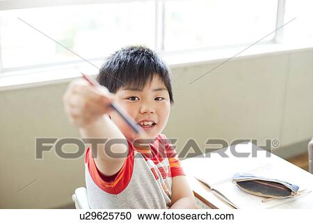 Stock Image - Boy Holding Up Pencil. Fotosearch