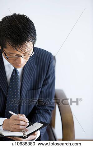 Stock Image - Bsuinessman Writing in Notebook. Fotosearch