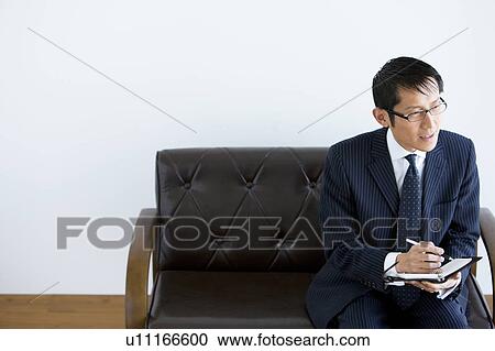 Stock Image - Bsuinessman Writing in Notebook. Fotosearch