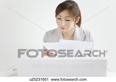 Stock Image - Businesswoman Working at Desk. Fotosearch